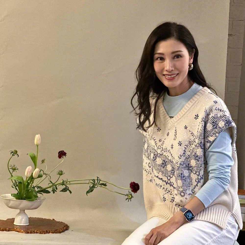 Lý Gia Hân ngồi bên cạnh chậu hoa