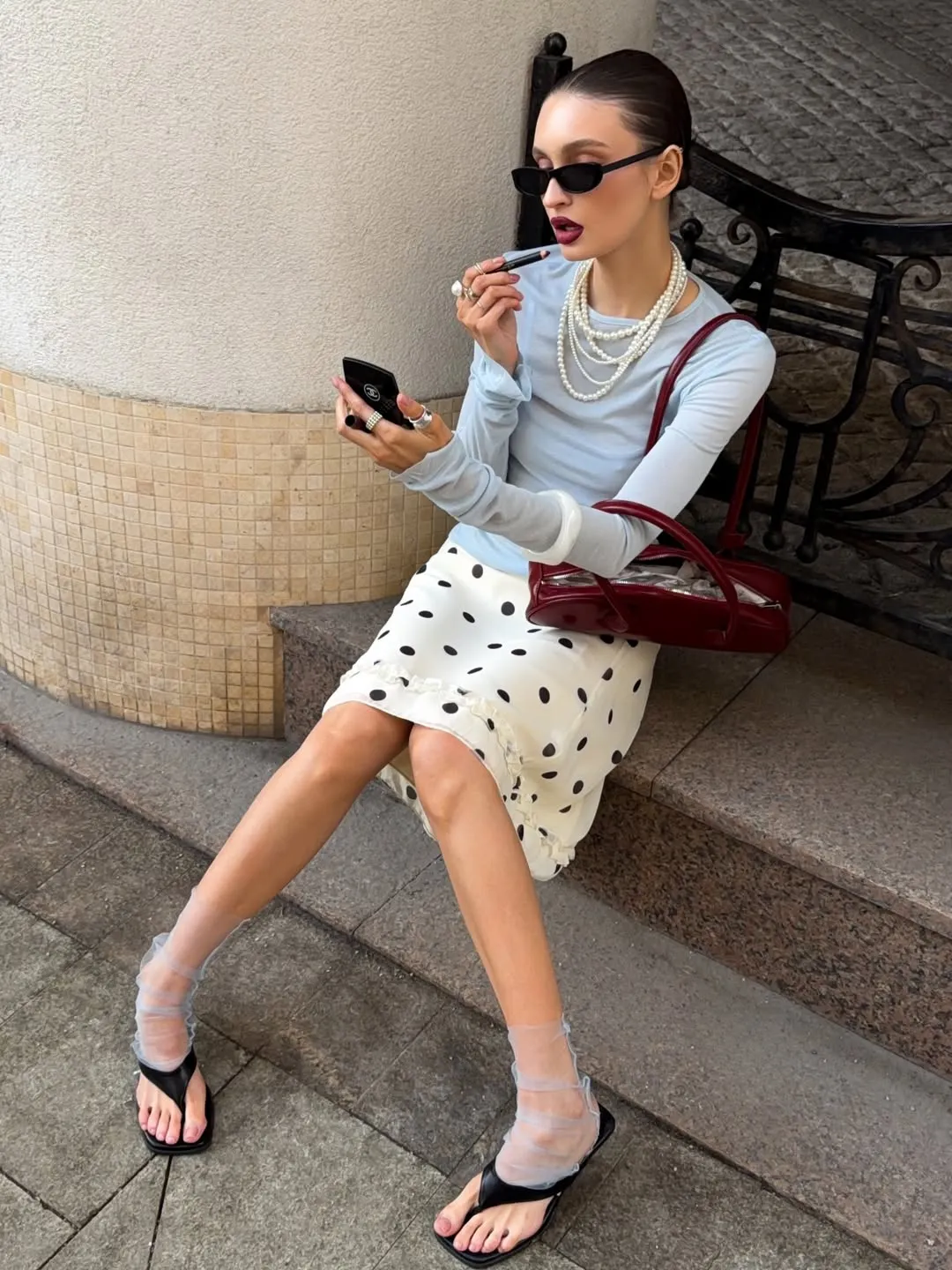 Sự kết hợp giữa vớ lụa mỏng tang và dép xỏ ngón quai mảnh màu đen basic, tạo hiệu ứng thị giác độc đáo.