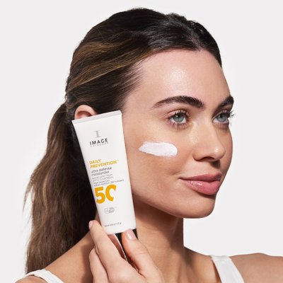 Cô gái cầm tuýp kem chống nắng từ thương hiệu Image Skincare