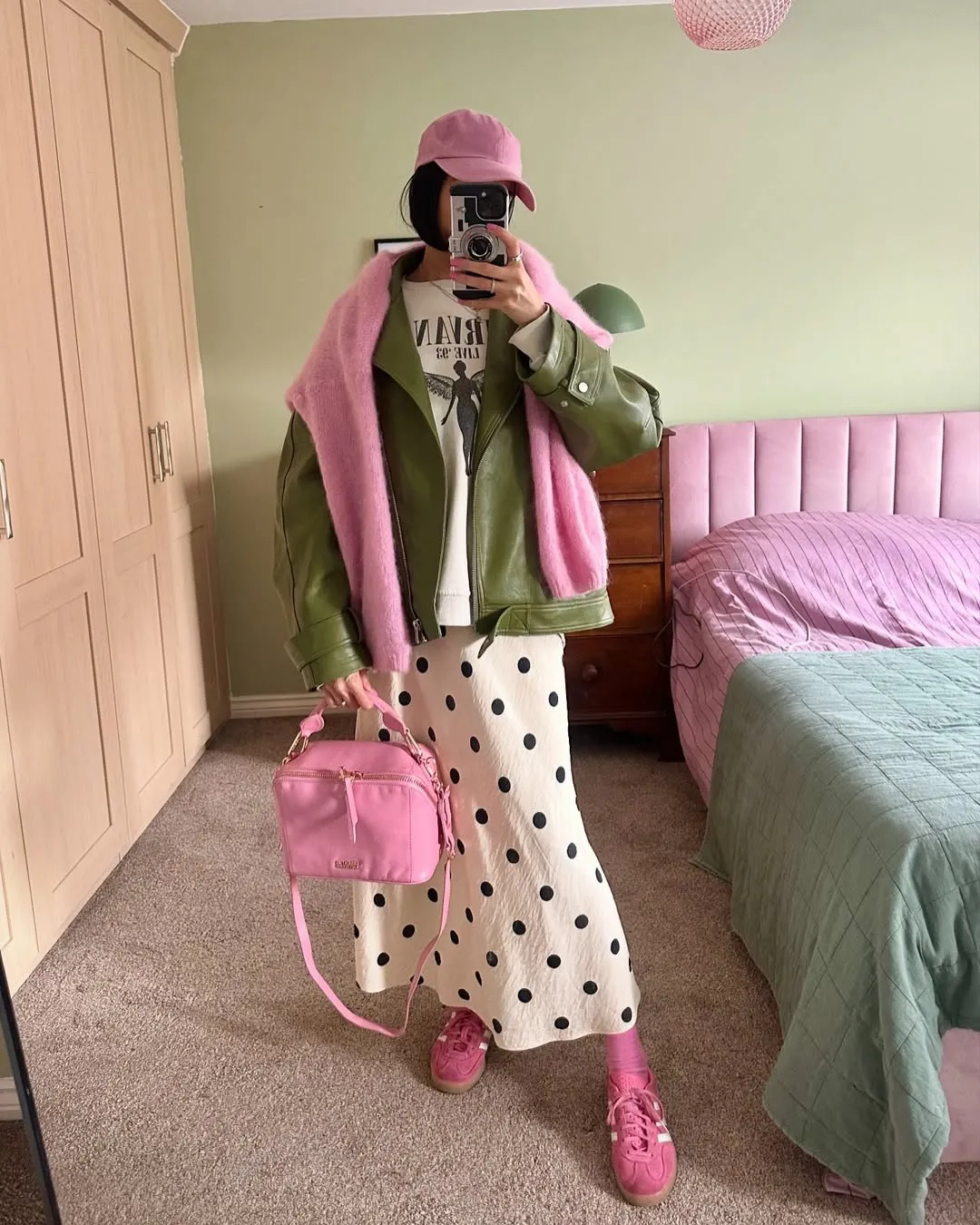 Áo khoác xanh lá kết hợp cùng khăn và túi xách hồng