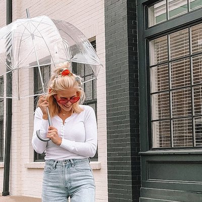 bảo quản quần áo mùa mưa cô gái cầm ô đứng dưới mưa - feature