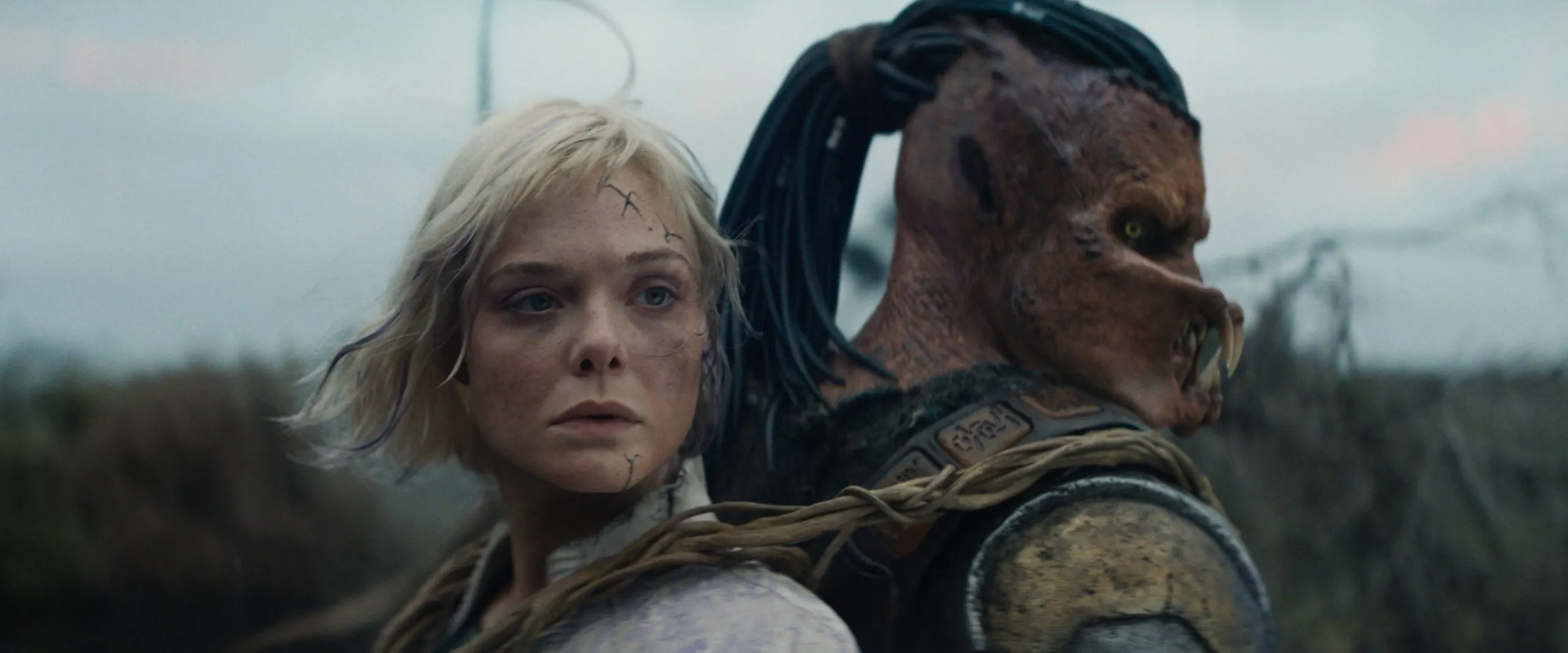 Predator Dek nhận được sự trợ giúp của người máy Thia (Elle Fanning) trong phim Predator Badlands
