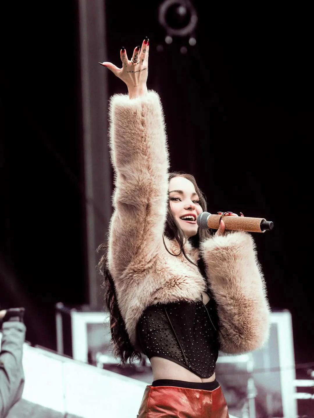 Dove Cameron tỏa sáng trên sân khấu ca nhạc với chiếc Grace Long sleeve Crop Jacket lông màu kem của FANCÌ CLUB, phối cùng corset đính đá nổi bật.