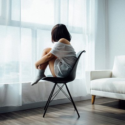 cô gái áo trắng ngồi trên ghế đen