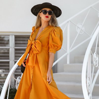 cô gái mặc đầm vàng mù tạt đội mũ đen
